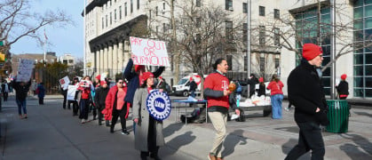 Union members march in a circle on Monday afternoon in front of Queens Civil Court.